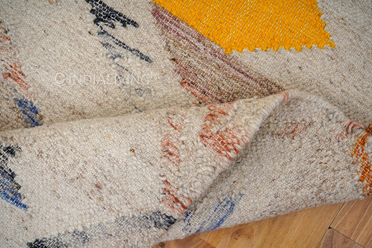 Close-up of handwoven texture on beige abstract rug