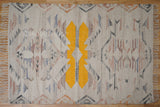 Beige abstract kilim rug under a coffee table