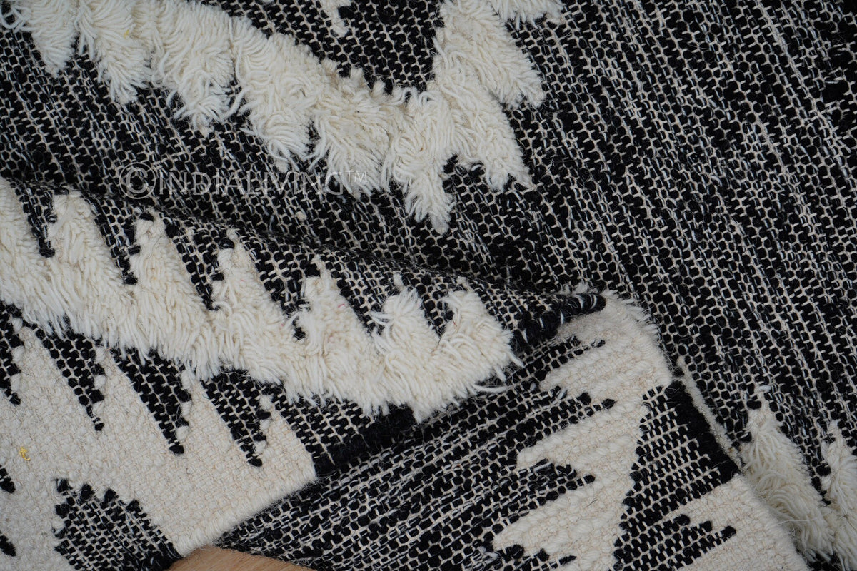 Black rug corner detail with fringe edge