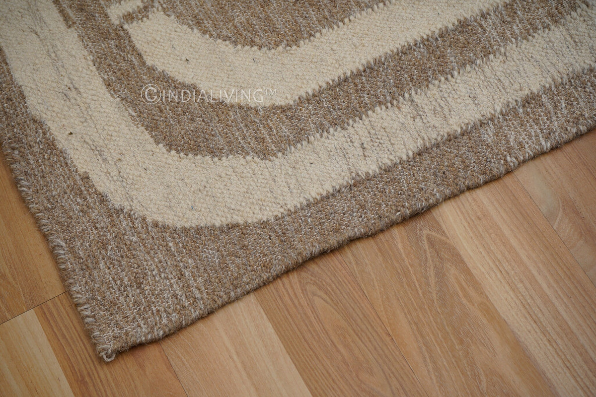 Wide shot of brown beige kilim rug on floor