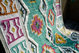 Green Moroccan rug placed in a bedroom setting
