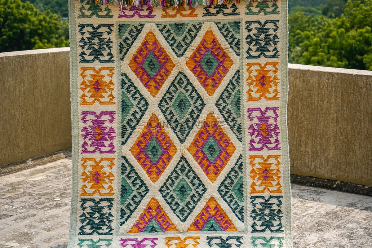 Green tribal wool rug under a coffee table