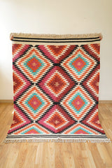 Rainbow kilim rug styled in a bedroom setting