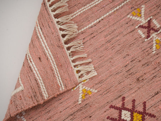 Pink kilim rug styled in a living room