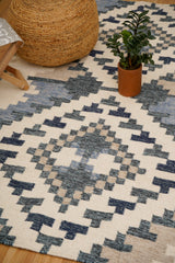 Wide shot of beige blue kilim rug in a bright room