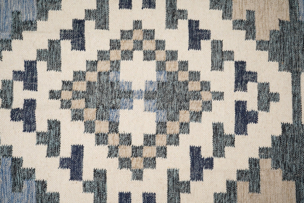 Full view of beige blue abstract kilim rug on floor