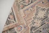Detail of fringe and knotted braid ends on pink rug