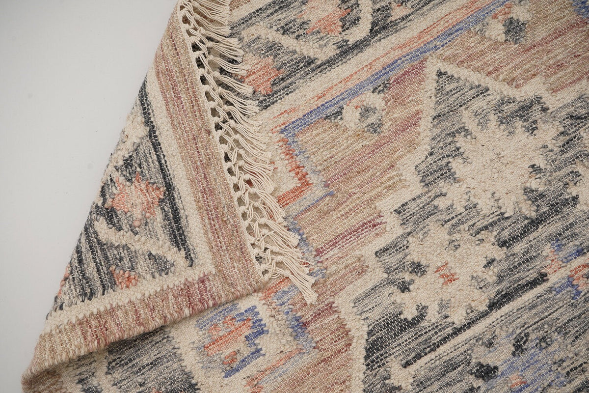Detail of fringe and knotted braid ends on pink rug
