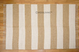 Ivory beige striped wool rug in a bedroom setting