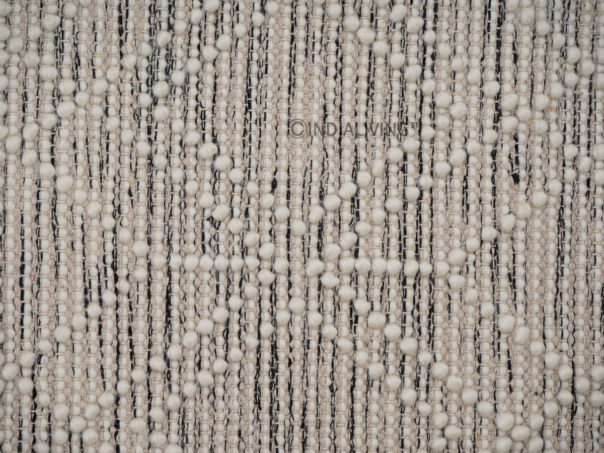 Beige wool rug styled in a living room