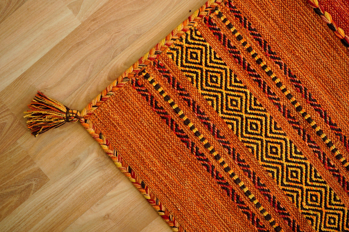 Full view of orange diamond pattern rug on floor