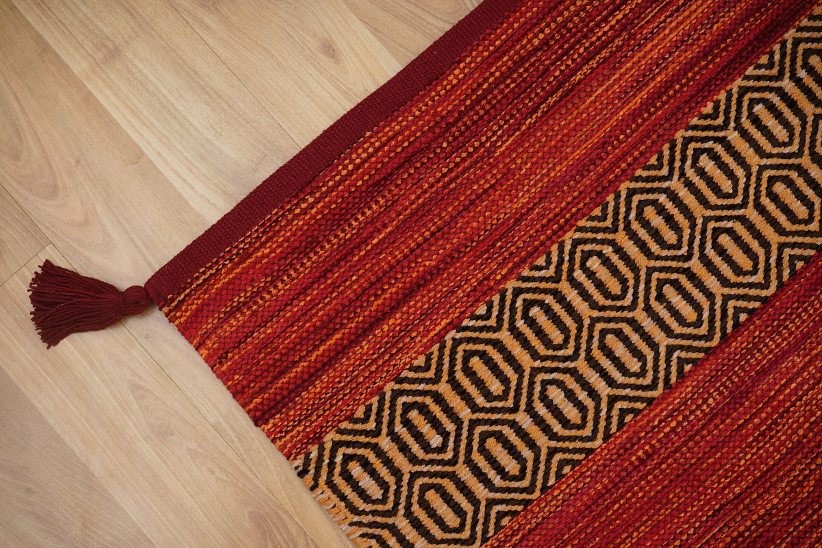 Corner detail of red kilim rug diamond pattern edge