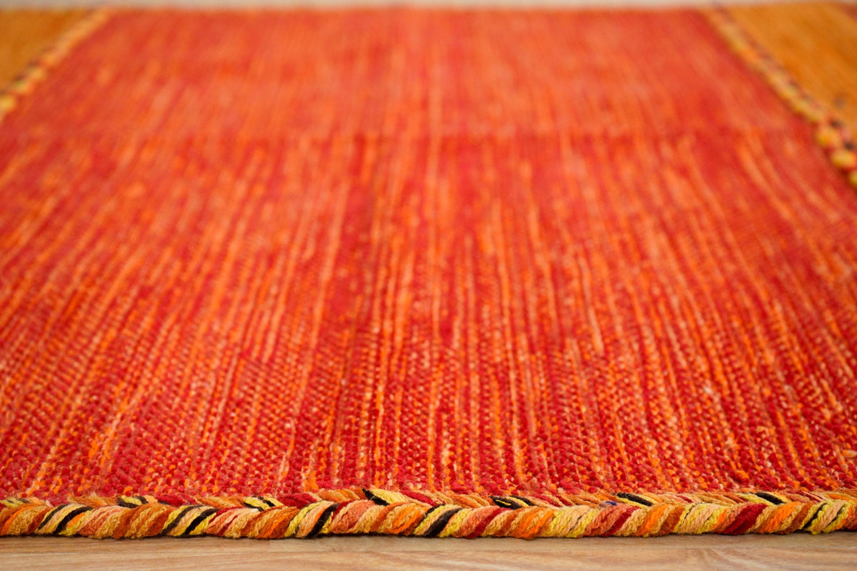 Orange kilim rug styled in bedroom