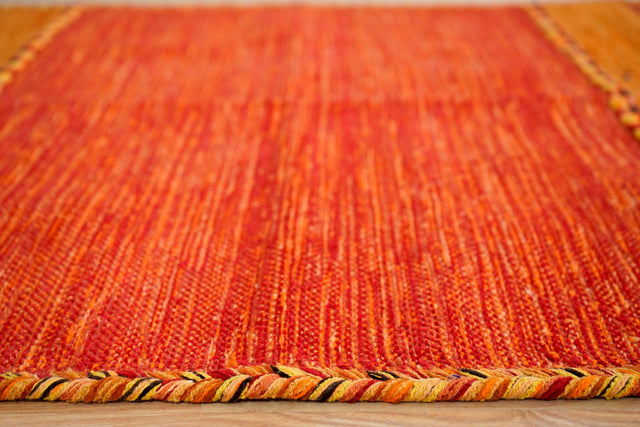 Orange kilim rug styled in bedroom