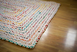 Rainbow rag rug placed in a bedroom setting