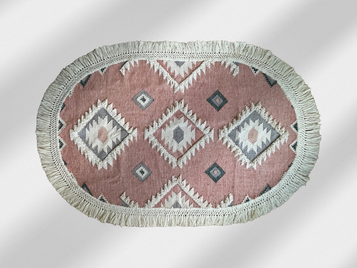 Pink oval rug styled in a bohemian living room
