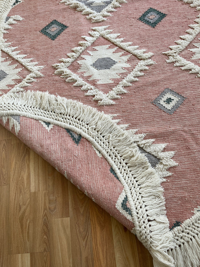 Pink oval wool shaggy rug flat lay showing full shape