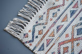 Corner detail of striped Moroccan ivory rug edge
