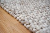 Beige wool rug placed in bedroom setting