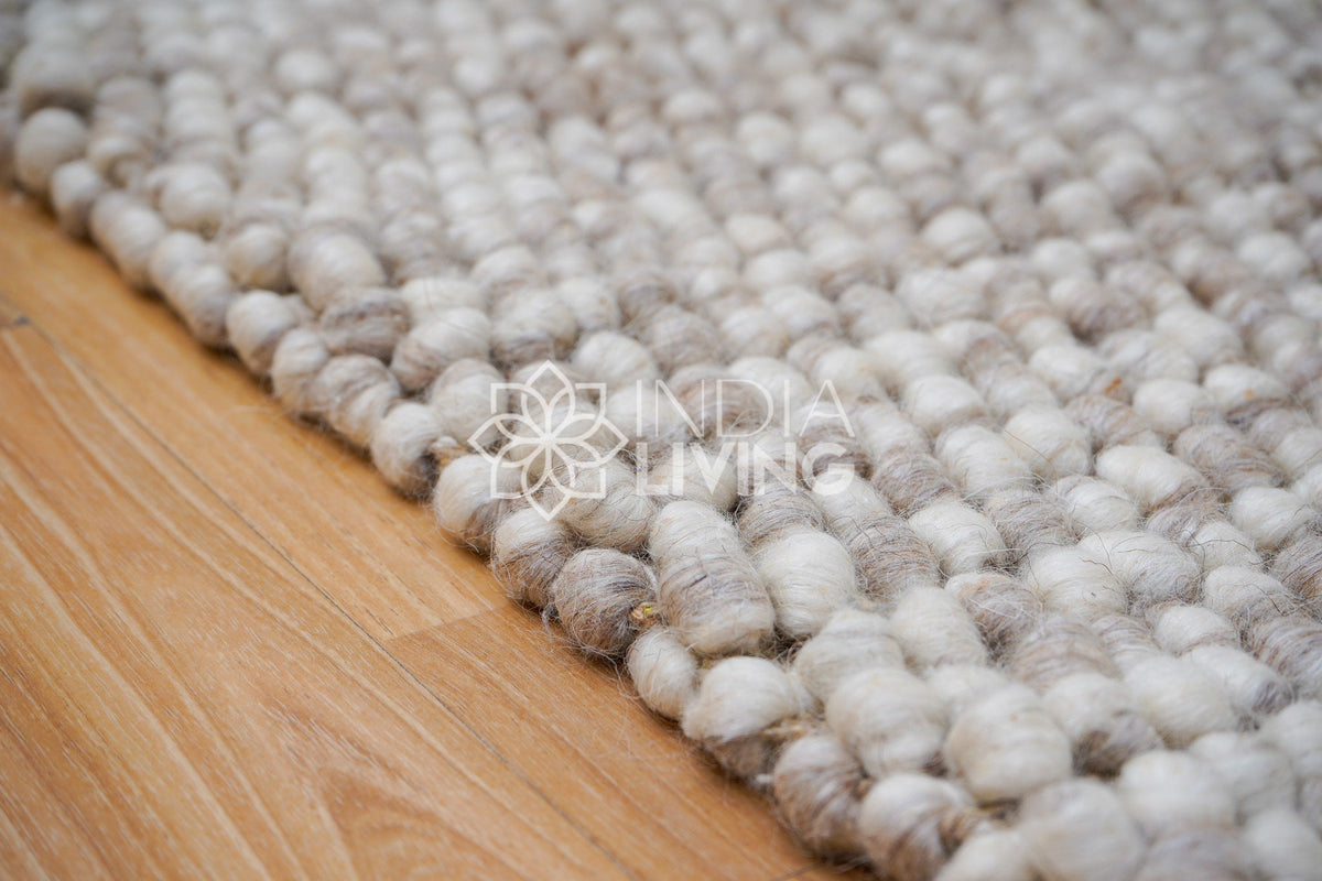 Beige wool rug placed in bedroom setting