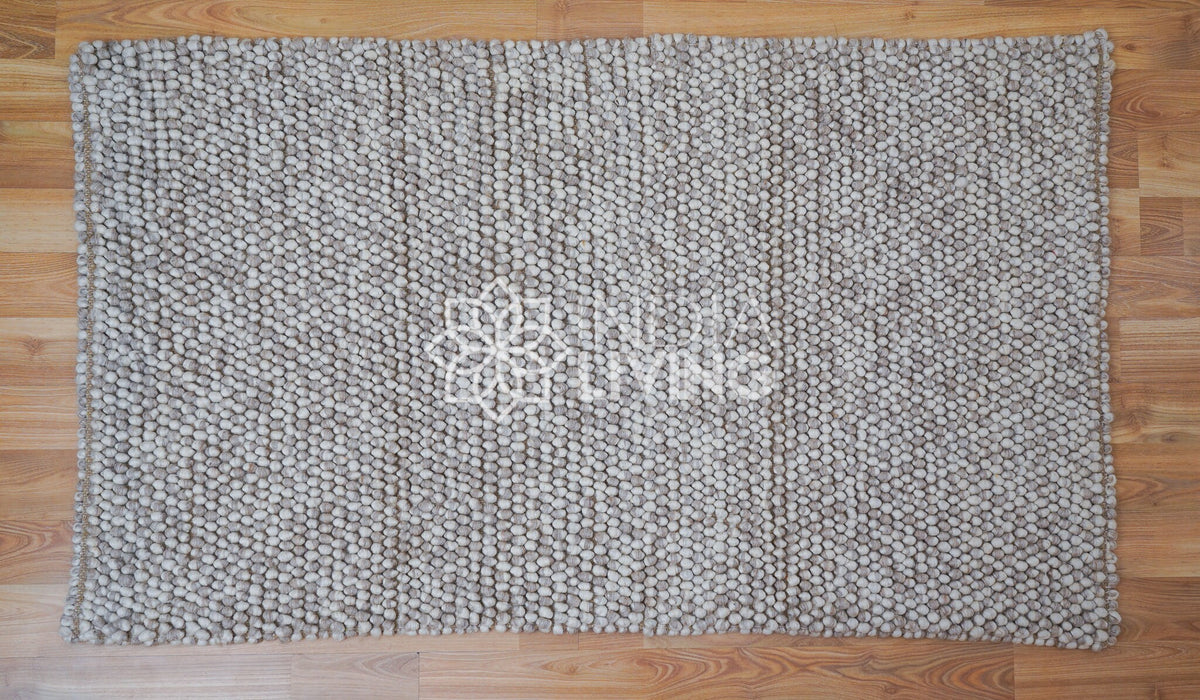 Beige wool rug in cozy styled room