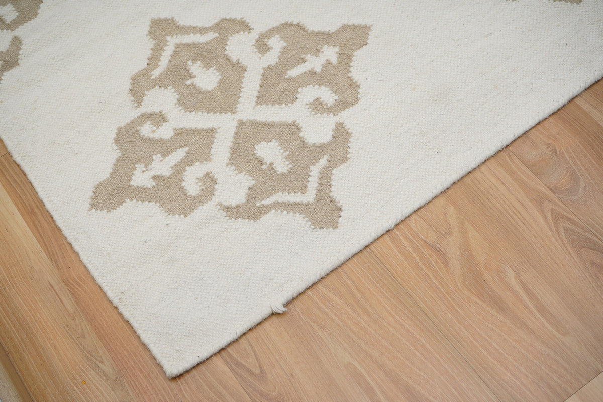 White wool kilim rug corner detail with braided edge