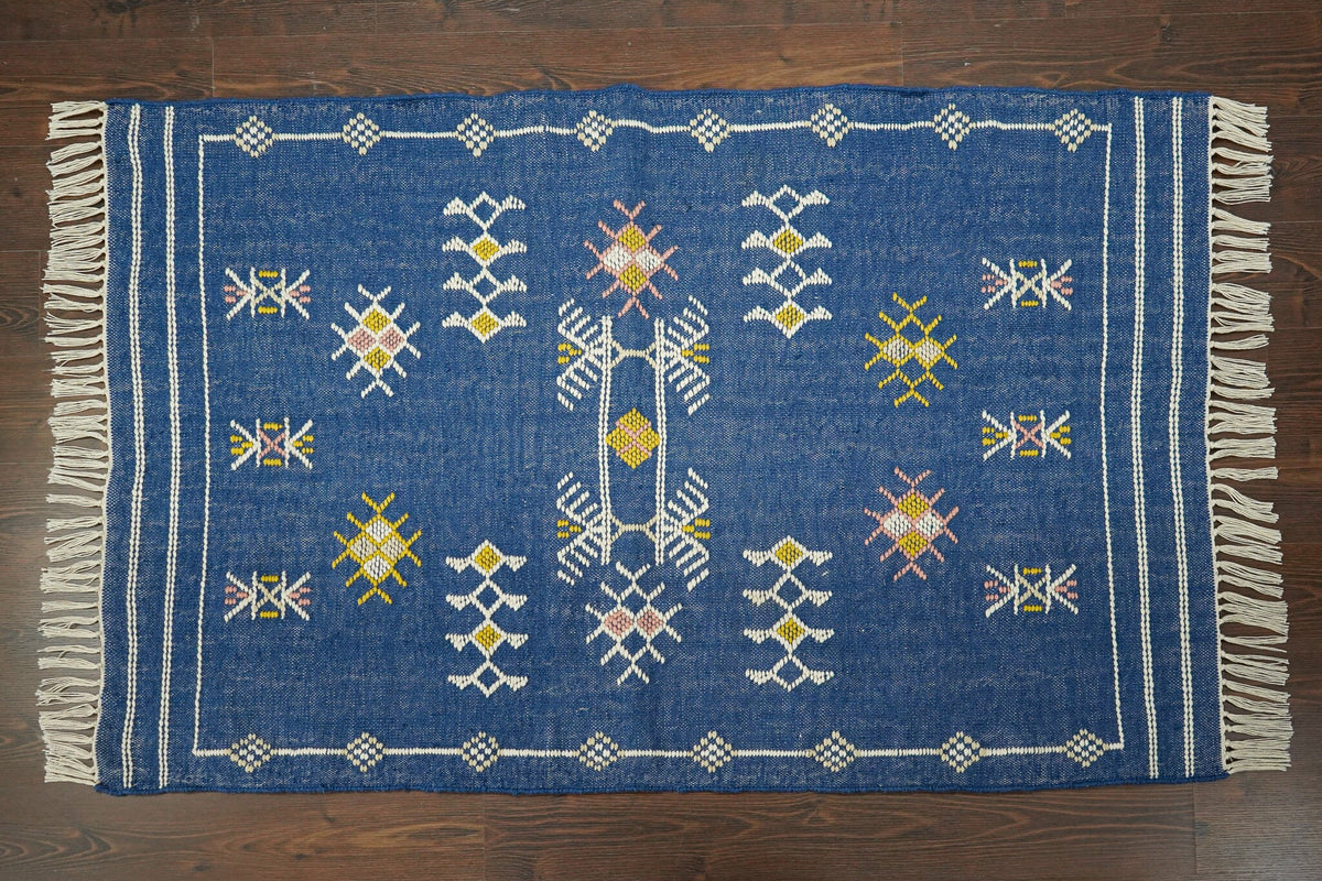 Blue kilim rug styled in a bohemian bedroom