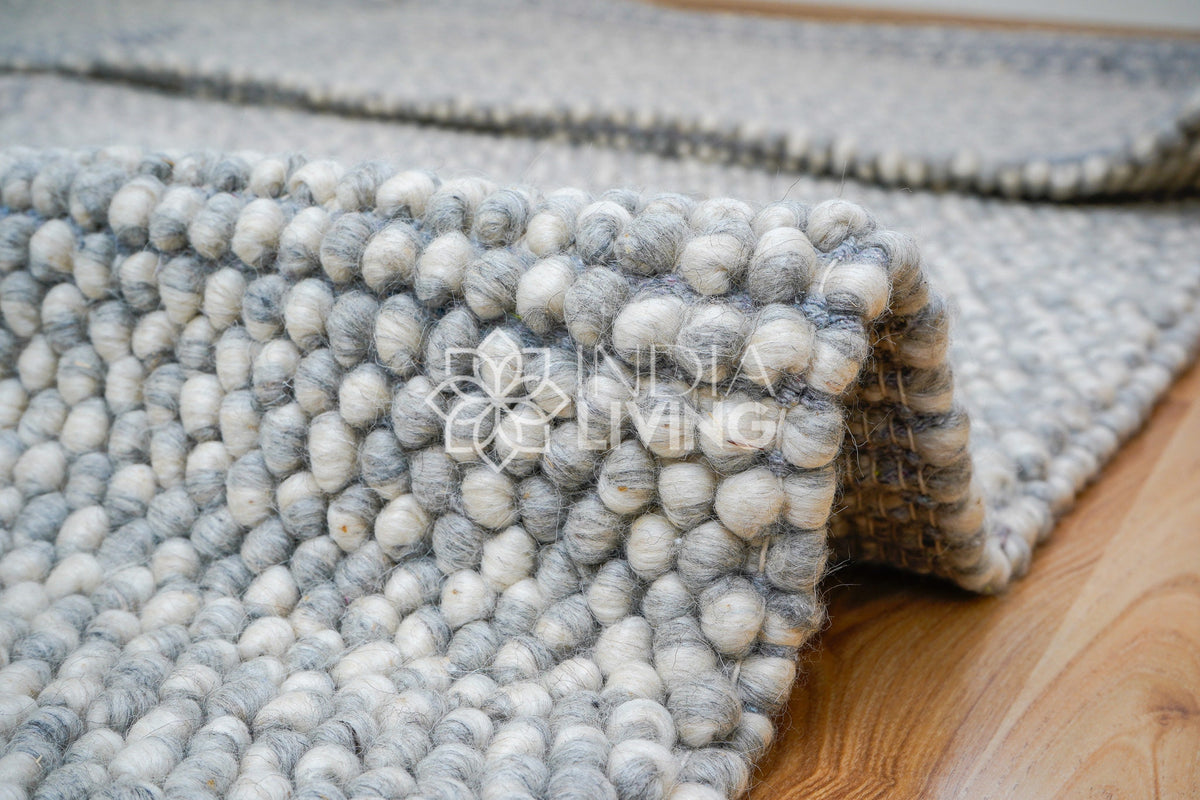 Grey wool rug styled in Scandinavian living room