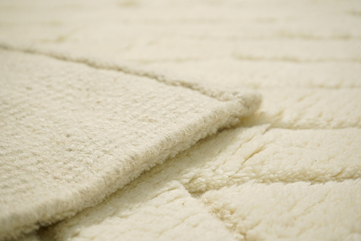 Close-up of hand-knotted texture on ivory abstract rug