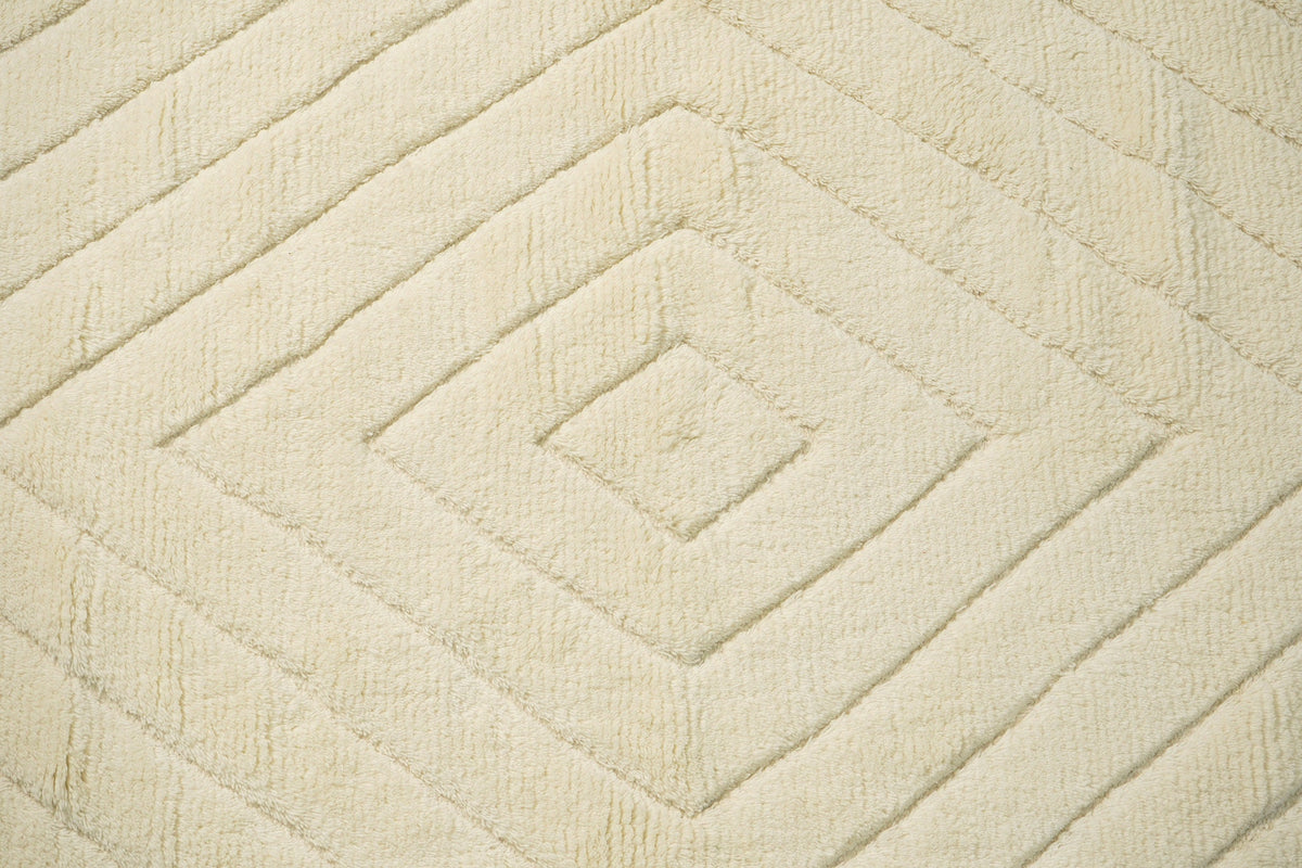 Wide shot of ivory geometric rug in a bright room