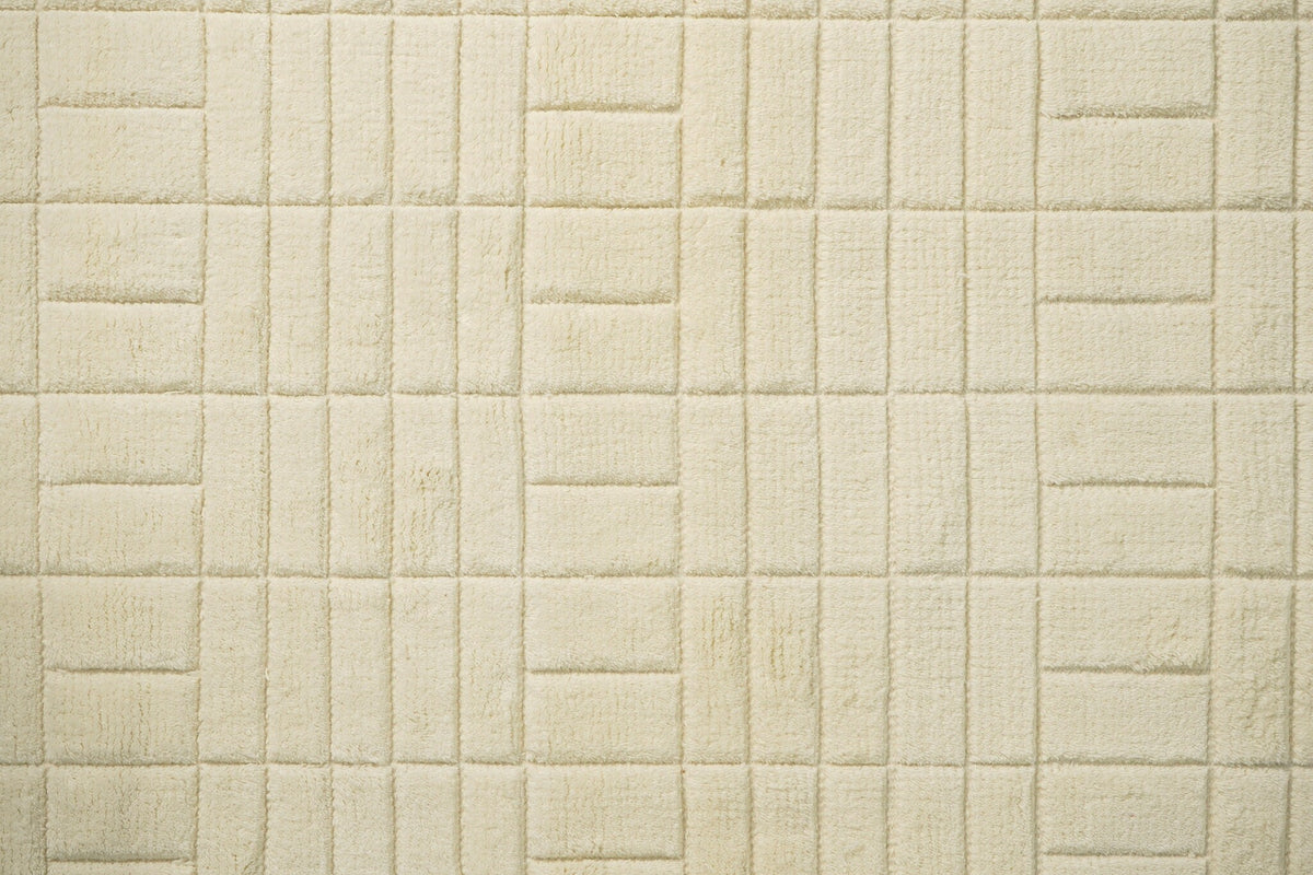 Close-up of hand-knotted texture on minimalist ivory rug