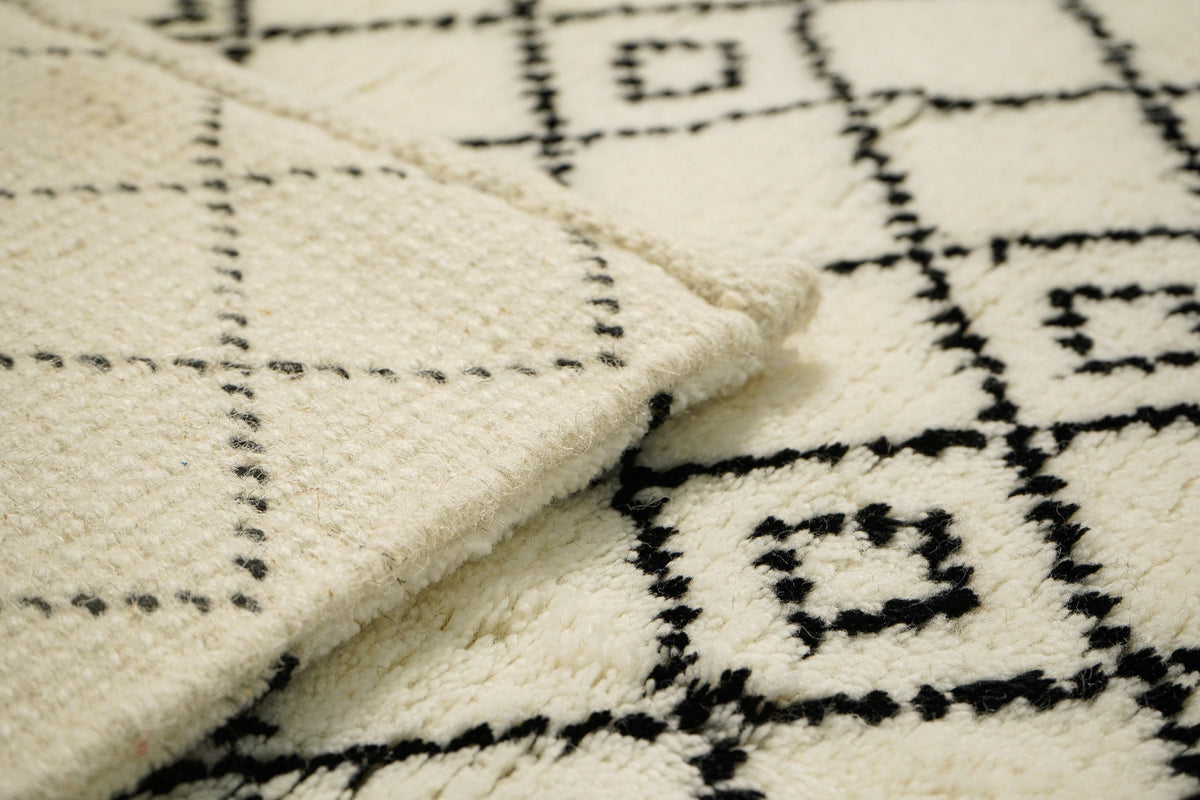 Ivory Berber wool rug under a bed