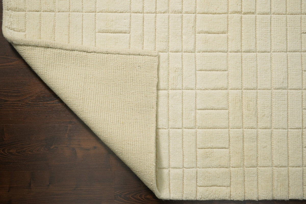 Minimalist ivory rug styled with neutral furniture