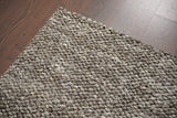 Charcoal brown chunky wool rug rolled showing thickness