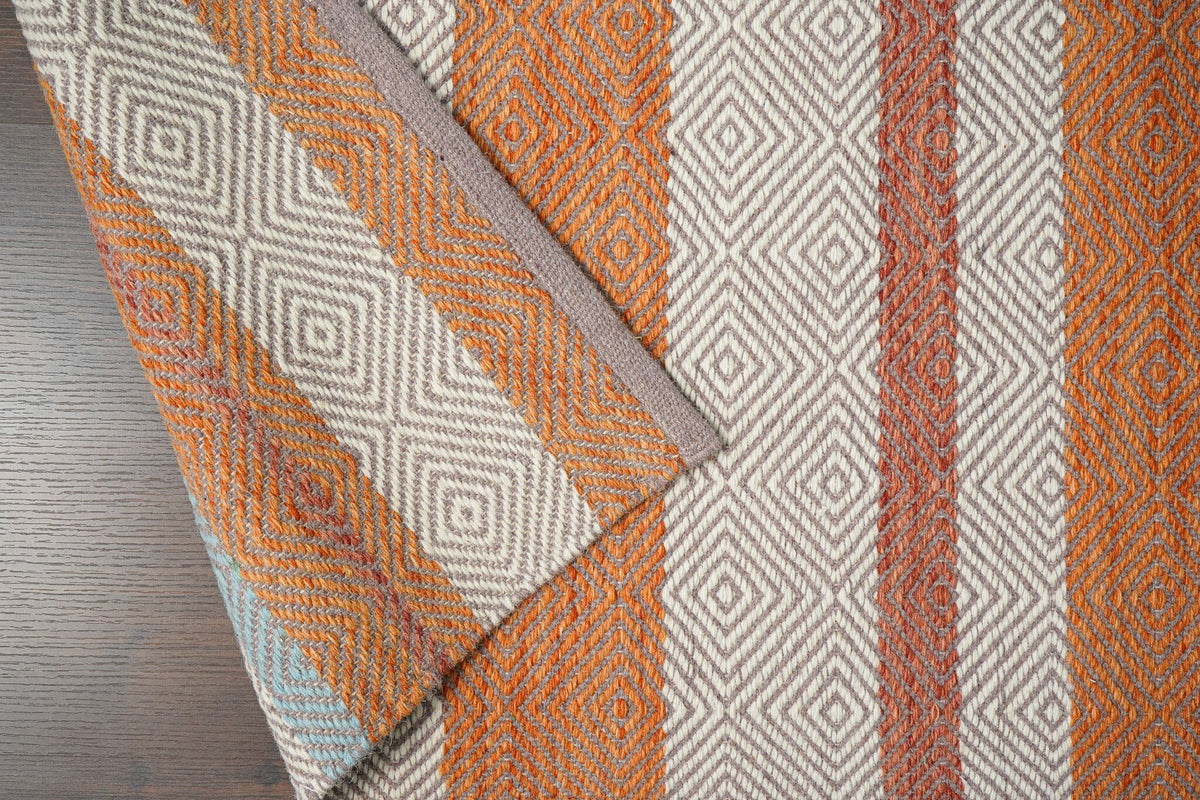 Orange wool rug placed under furniture in room