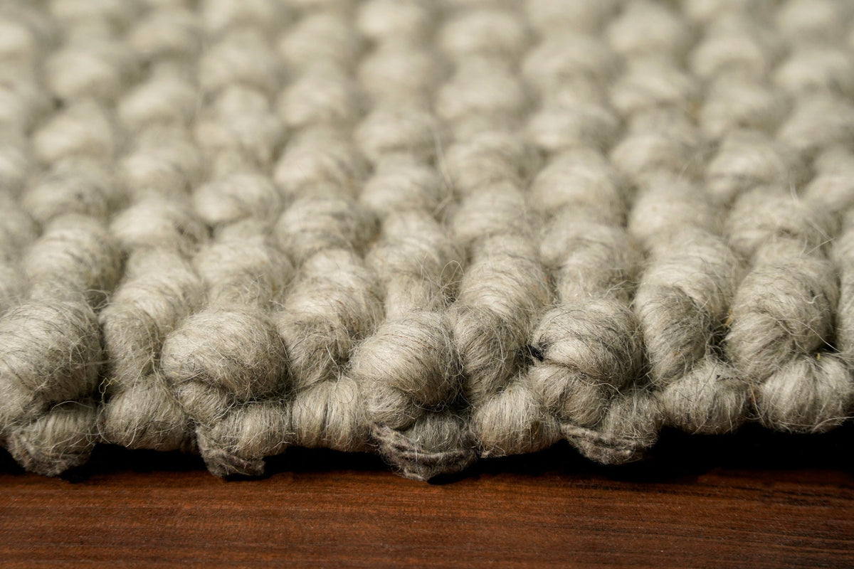 Grey wool rug styled in a living room
