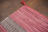 Full view of pink 8x10 kilim rug on wood floor