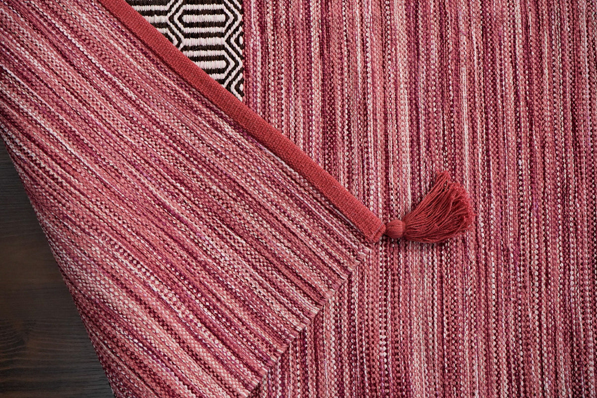 Pink kilim rug shown at an angle in room decor