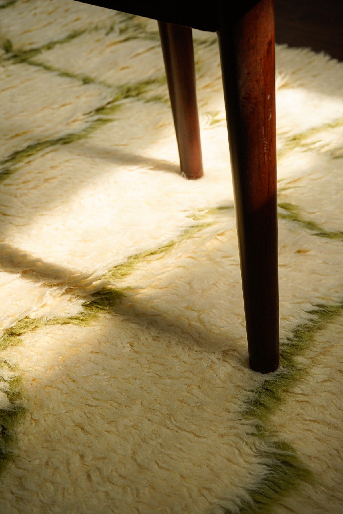 Full view of green Berber wool rug in natural light