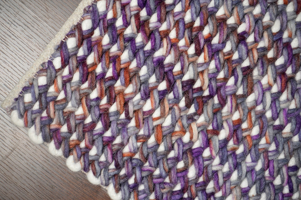 Textured pile close-up of purple wool rug