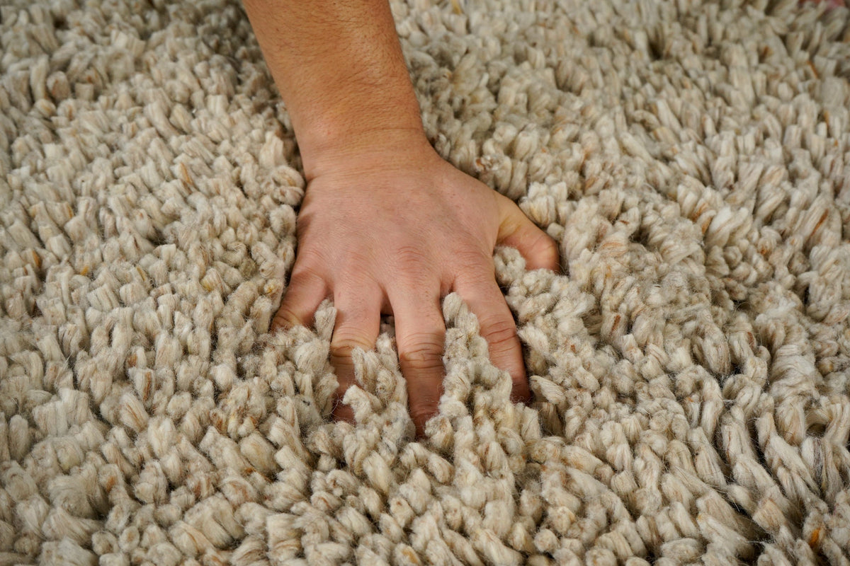 Beige shaggy wool rug flat view