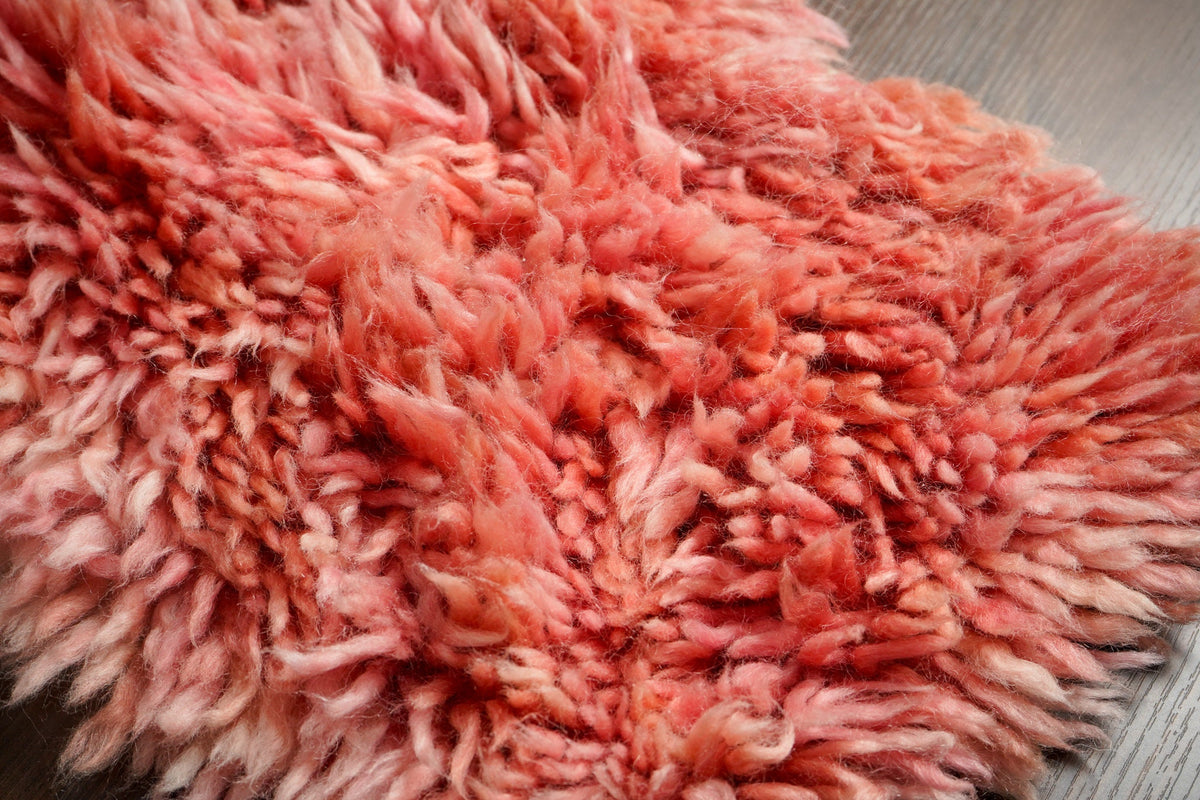 Close-up of pink shaggy wool pile texture