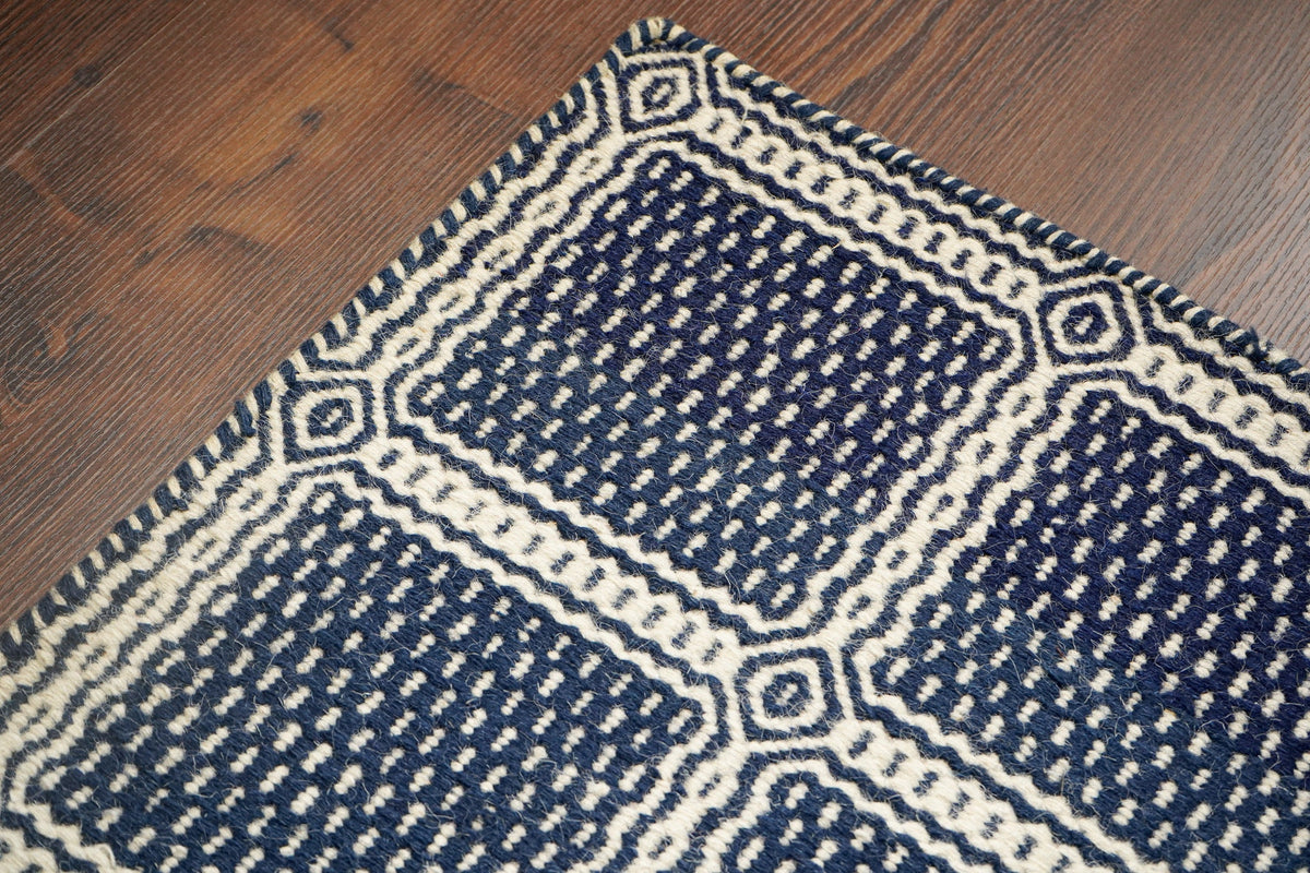 Blue wool rug styled in a bedroom