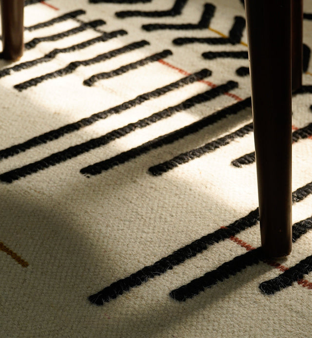 Ivory flatweave rug styled in a living room setting