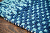 Blue wool rug placed in a bedroom corner