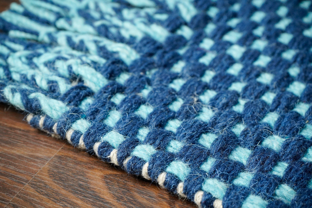 Blue wool rug placed in a bedroom corner
