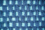 Blue rug corner detail showing knotted pattern