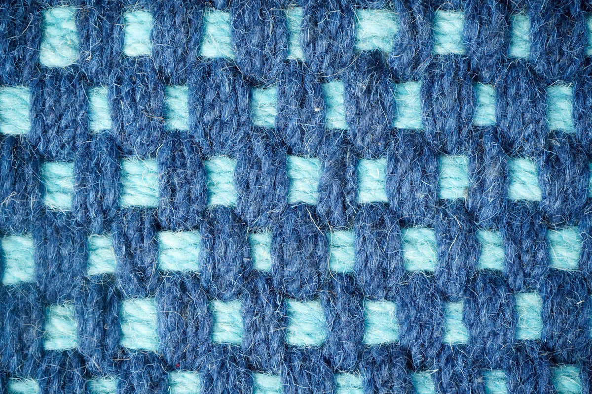 Blue rug corner detail showing knotted pattern