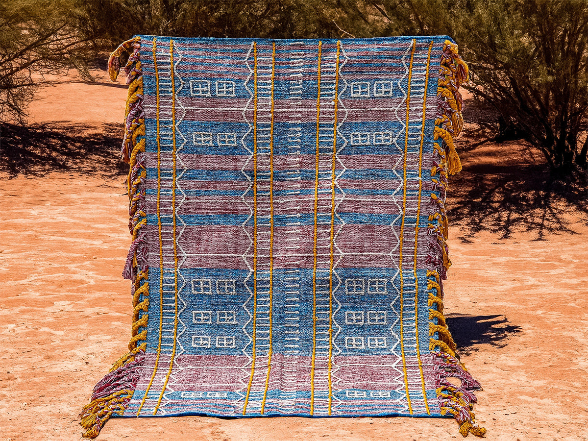 Blue-purple kilim rug styled in a bohemian living room