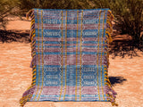 Blue-purple kilim rug styled in a bohemian living room